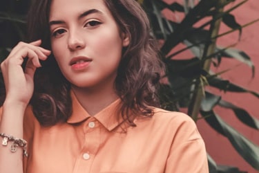 a young woman presenting orange shirt and a bracelet