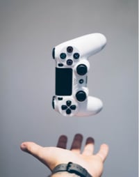 a console controller mid-air being caught by a hand beneath it